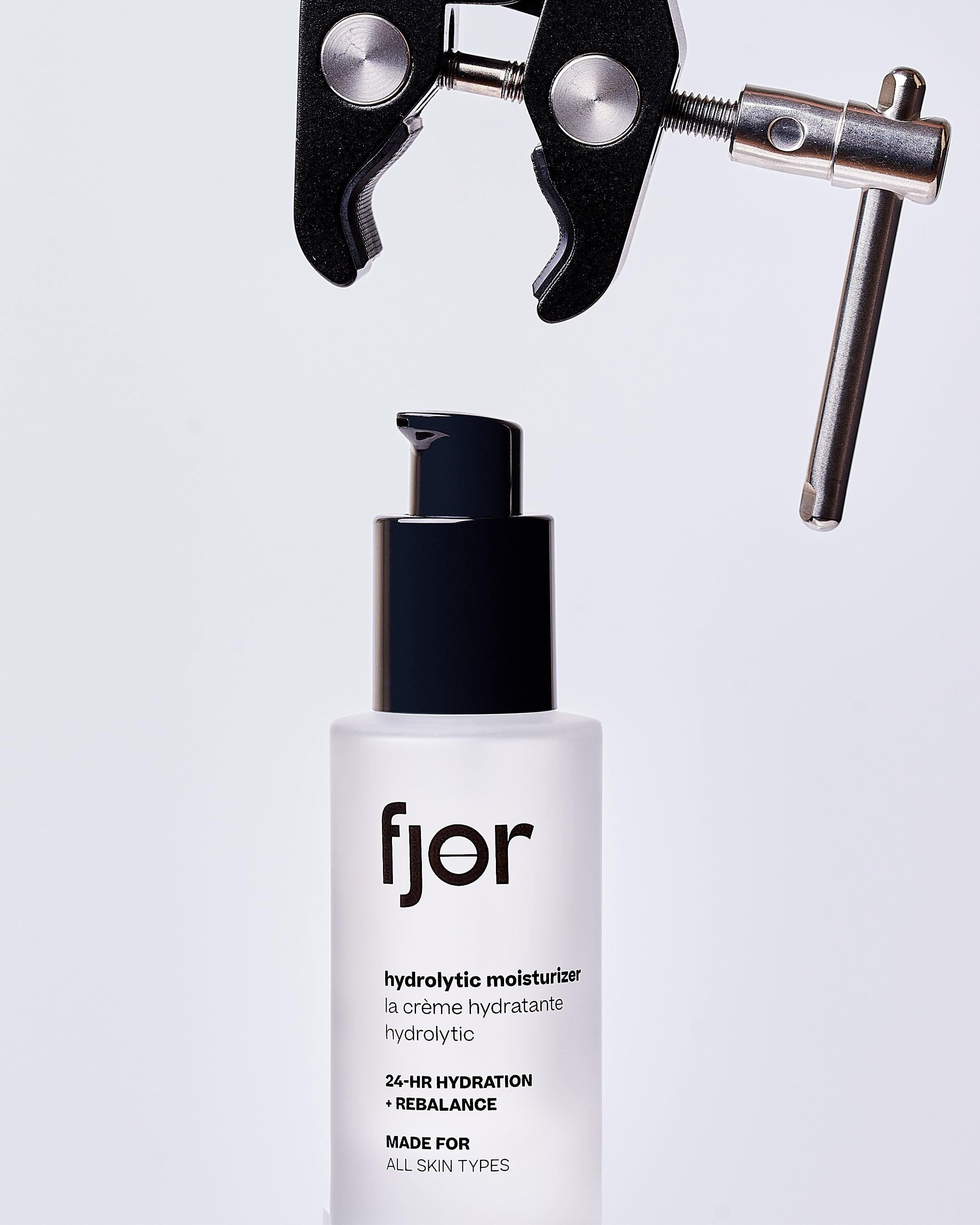 a bottle of the hydrolytic moisturizer with a scientific clamp suspended above