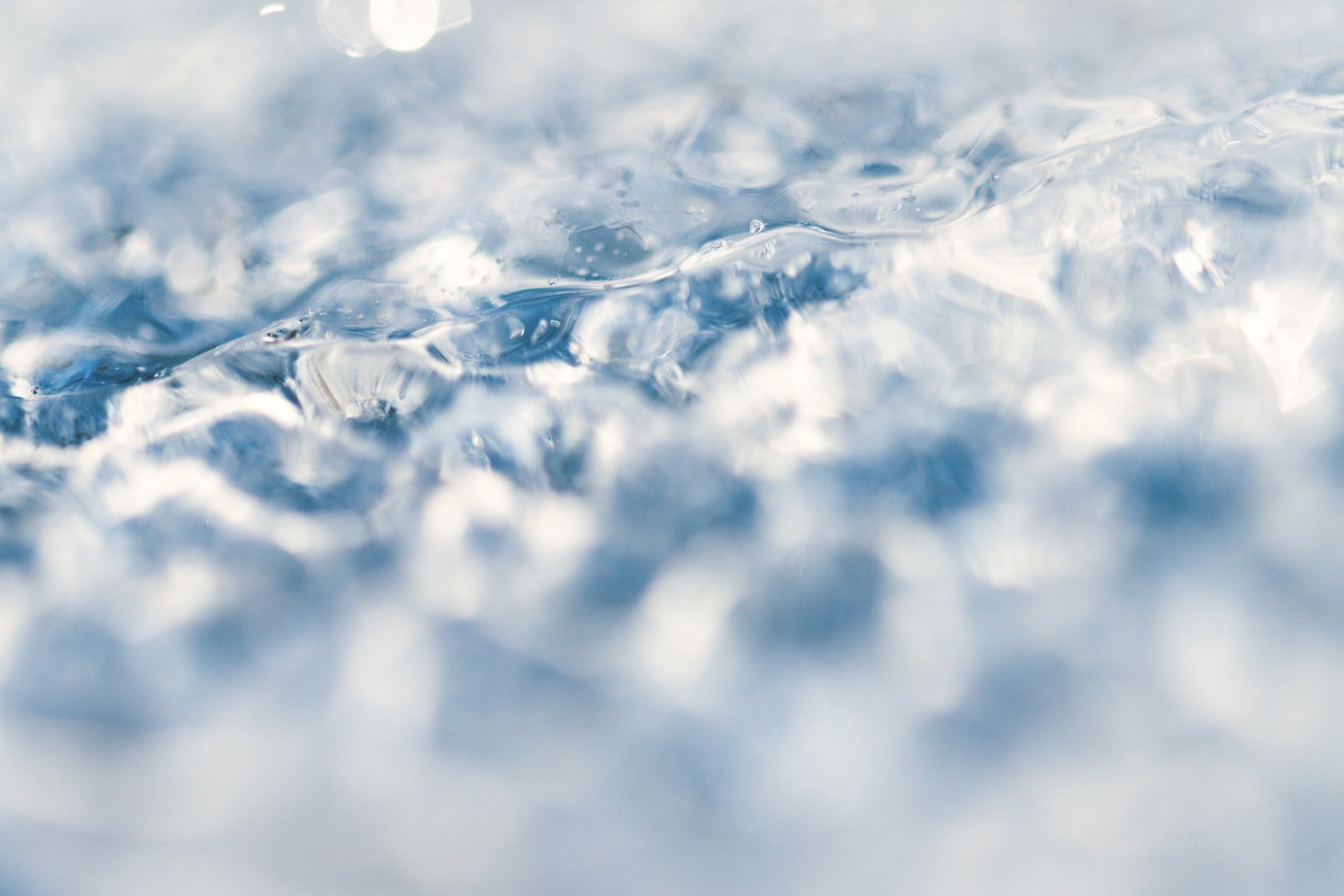 a closeup image of an icy surface with a gentle gradient of blue hues