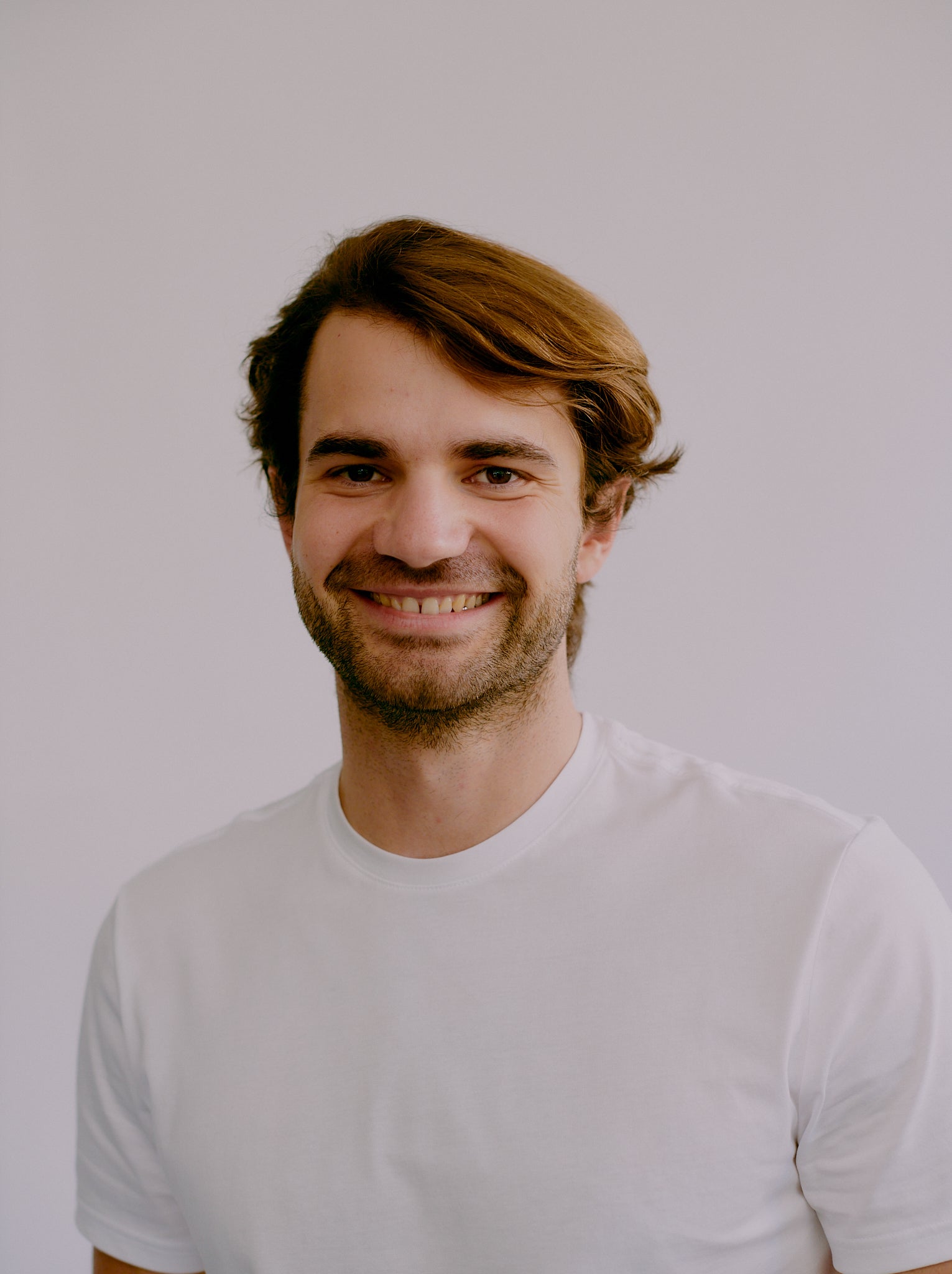 a portrait photo of Will Smithwhite the co-founder of fjör standing in a white shirt with a white background