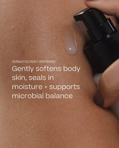 Close-up of a hand pressing a black pump bottle onto a person's skin, with a translucent gel drop visible and white text reading 'DERMATOLOGIST APPROVED Gently softens body skin, seals in moisture + supports microbial balance'.