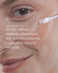 Close-up of a person's face with a clear dropper applying serum near the eye, with white text overlay reading 'DERMATOLOGIST APPROVED' and 'Gently refines texture, rebalances the skin microbiome + supports natural renewal'.